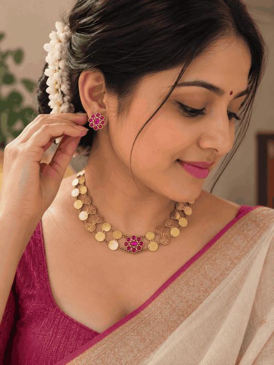 Model wearing antique gold look Kasu Mala coin necklace set with pink stone accents and matching earrings