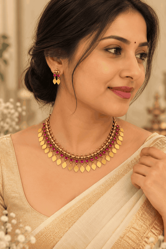 Model wearing antique gold look Elakkathali necklace set with pink stones and matching earrings by House of Praniv