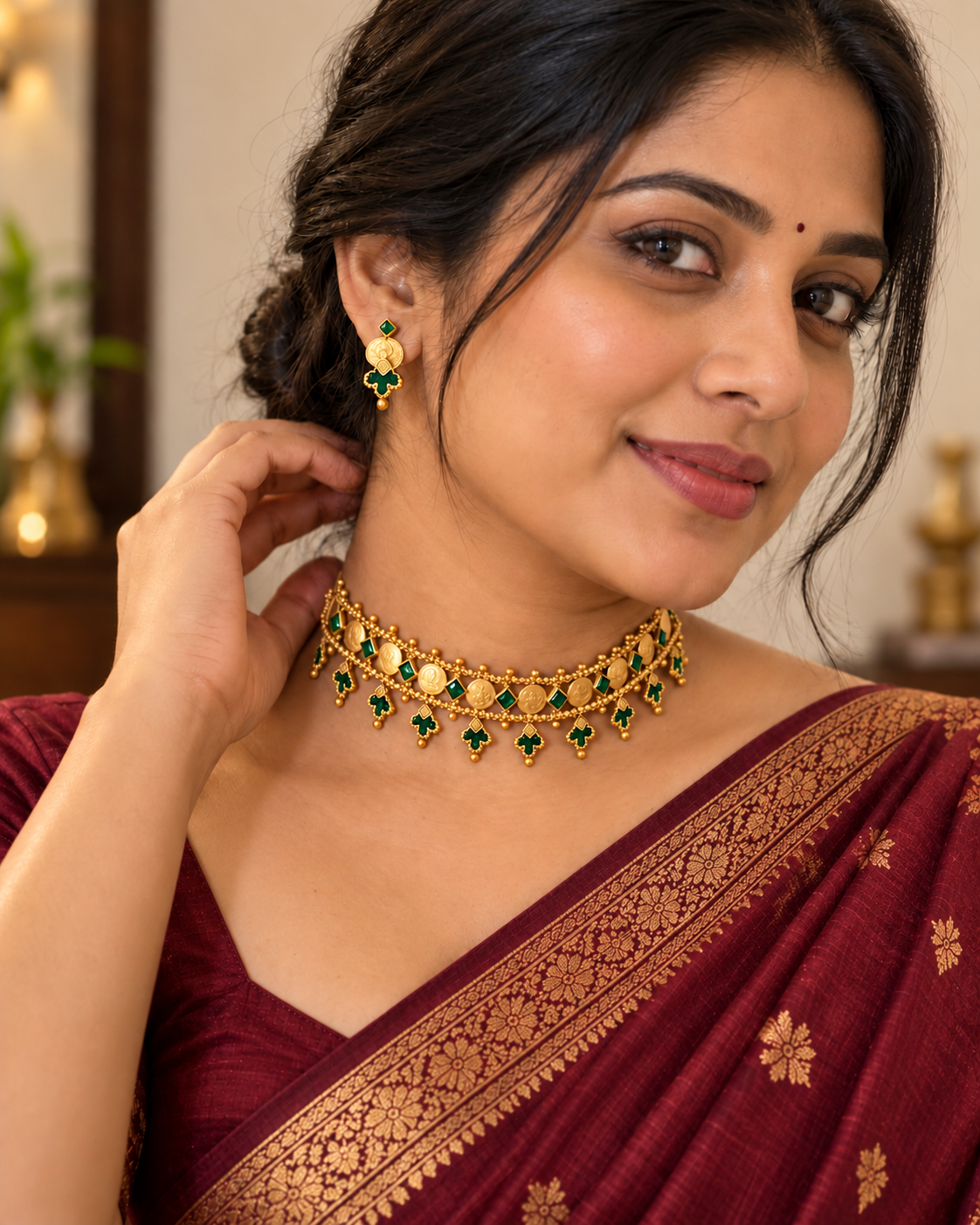 Model wearing antique gold look coin choker necklace set with green stones and matching earrings by House of Praniv