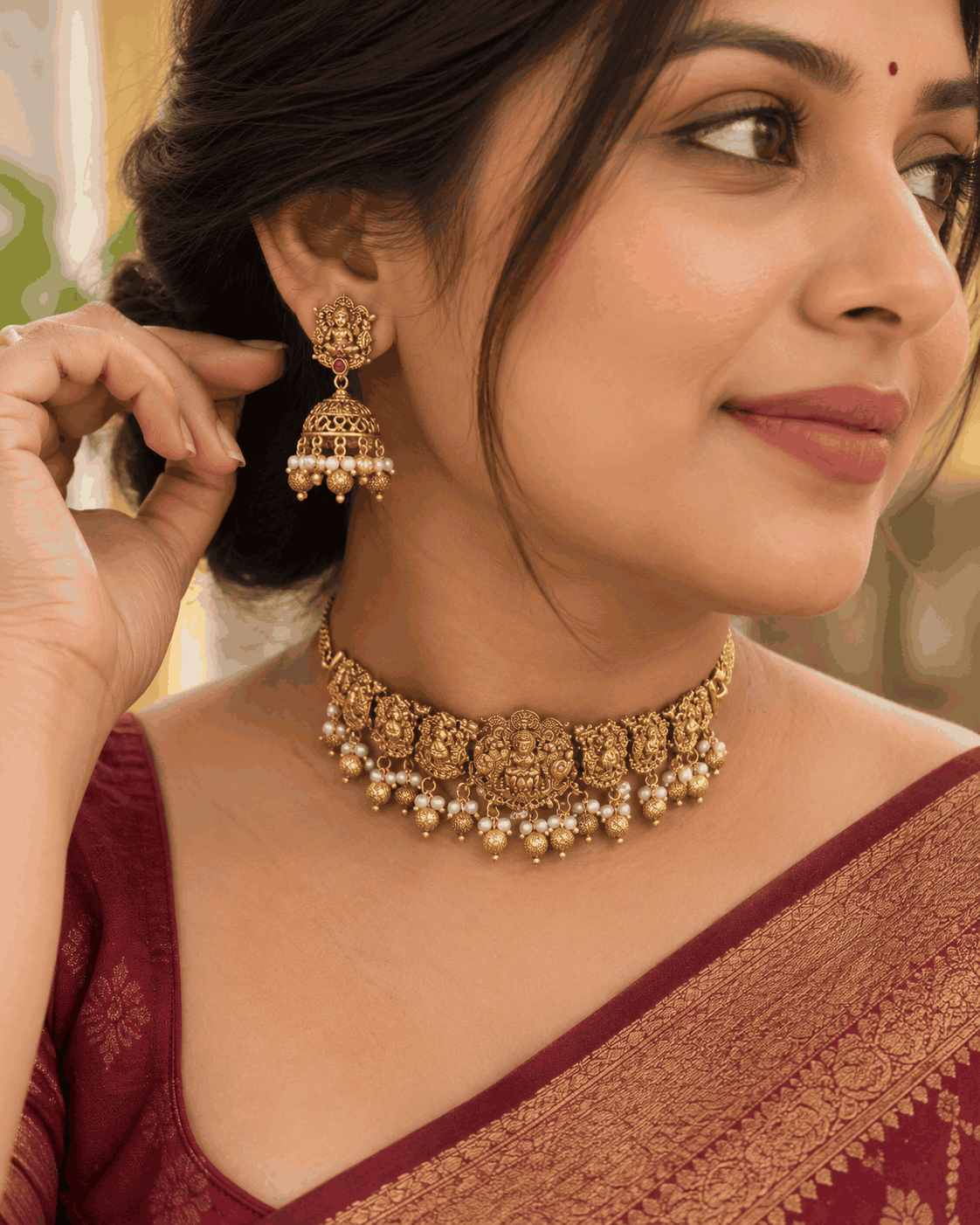 Model wearing antique gold look Lakshmi temple choker necklace with pearl-like drops and matching jhumka earrings by House of Praniv.