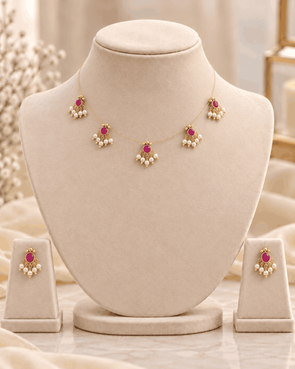 Delicate reversible invisible chain necklace displayed on mannequin with pink stone detailing and matching earrings.