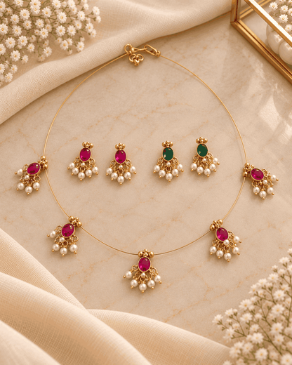 Reversible pink and green invisible chain necklace set with pearl-like drops and two matching pairs of earrings.