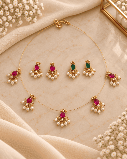 Reversible pink and green invisible chain necklace set with pearl-like drops and two matching pairs of earrings.